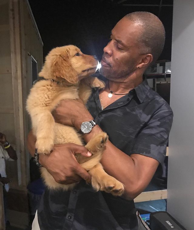Eriq La Salle posing with his pet in a black shirt.